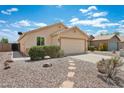 Inviting home exterior with a spacious driveway, low-maintenance landscaping, and a welcoming facade at 1945 W Renaissance Ave, Apache Junction, AZ 85120