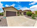 A spacious home showing the driveway, lush landscaping, and three-car garage at 20642 N 268Th Dr, Buckeye, AZ 85396