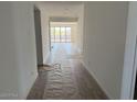 Long hallway with wood-look flooring leads to a bright living area with sliding glass doors and natural light at 32677 N Newby Dr, San Tan Valley, AZ 85143