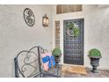 Welcoming front door with a decorative wreath, outdoor seating, and decorative plants at 3440 E Topeka Dr, Phoenix, AZ 85050