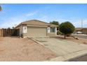 View of the home with a two-car garage and extended driveway surrounded by well-maintained landscaping at 35656 N Shorthorn Trl, San Tan Valley, AZ 85143