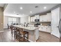 Modern kitchen featuring a large center island, stainless steel appliances, and stylish wood flooring at 35773 N Loemann Dr, San Tan Valley, AZ 85143