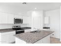 Modern kitchen showing a granite island countertop and a stainless steel appliance set at 469 W Bunker Hill St, Florence, AZ 85132