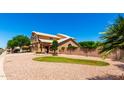 A charming home features a well-manicured front yard with a stone fountain and mature trees at 5216 W Oraibi Dr, Glendale, AZ 85308