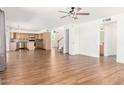 Open floor plan with hardwood floors, neutral paint and view into kitchen and staircase at 5216 W Oraibi Dr, Glendale, AZ 85308