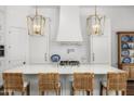 Bright kitchen features custom white cabinetry, an oversized island with seating, and designer pendant lights at 5542 E Alan Ln, Paradise Valley, AZ 85253