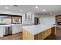 Bright kitchen with white cabinets, stainless steel appliances, and a large island with a quartz countertop at 6019 E Windsor Ave, Scottsdale, AZ 85257