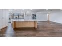 Open-concept kitchen featuring white cabinets, stainless steel appliances, an island and hardwood floors at 6019 E Windsor Ave, Scottsdale, AZ 85257