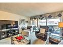 Relaxing living room with a plush armchair, entertainment center, and glass table with a balcony view at 7625 E Camelback Rd # A249, Scottsdale, AZ 85251