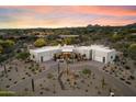 Stunning desert home featuring a circular driveway, two garages, and desert landscaping under a beautiful sunset sky at 9022 E Diamond Rim Dr, Scottsdale, AZ 85255