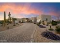 View of desert home displaying mature cacti, desert landscaping, a brick driveway and neutral exterior paint at 9022 E Diamond Rim Dr, Scottsdale, AZ 85255