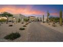 Desert home boasts mature cacti, desert landscaping and neutral tones with a brick driveway at 9022 E Diamond Rim Dr, Scottsdale, AZ 85255