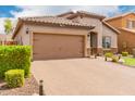 Charming single-story home featuring a tiled roof, neutral stucco, brick driveway, and well-kept bushes at 10738 W Rowel Rd, Peoria, AZ 85383