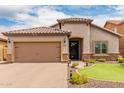 Inviting single-story home boasting a tiled roof, neutral stucco, stone accents and manicured lawn at 10738 W Rowel Rd, Peoria, AZ 85383