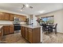 Modern kitchen featuring stainless steel appliances, wooden cabinetry, and a dining area at 10923 E Flower Ave, Mesa, AZ 85208