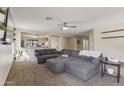 Spacious living room featuring a large sectional sofa and open access to the kitchen at 10923 E Flower Ave, Mesa, AZ 85208