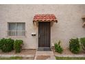Charming front door with a wrought iron security gate and red tiled awning at 1208 E Lawrence Ln, Phoenix, AZ 85020