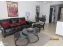 Inviting living room featuring a leather couch, layered tables, and decorative artwork at 12221 W Bell Rd # 209, Surprise, AZ 85378