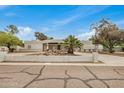 Single story house with white walls, decorative rock feature, and palm tree in front yard at 12821 N 67Th St, Scottsdale, AZ 85254