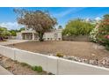 Single story house with white walls and gravel front yard, under a blue sky at 12821 N 67Th St, Scottsdale, AZ 85254