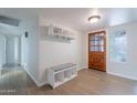 Bright entryway with hardwood floors, a storage bench, and a wooden front door with decorative glass at 2502 S Mollera Cir, Mesa, AZ 85210