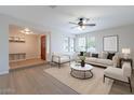 Bright living room featuring neutral tones, large windows, ceiling fan, and stylish furniture arrangement at 2502 S Mollera Cir, Mesa, AZ 85210