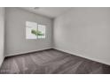 This bedroom features neutral walls, carpet flooring, a window, and electrical outlets at 2506 N Pony Ln, Casa Grande, AZ 85122