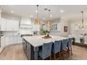 Bright kitchen featuring a large island with barstool seating, modern pendant lighting, and stainless steel appliances at 2851 E Alexander Ct, Gilbert, AZ 85298