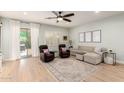 Cozy living room with light wood floors, comfortable seating, and a sliding glass door leading to the outside at 2851 E Alexander Ct, Gilbert, AZ 85298
