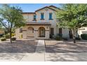 Charming two-story home with a tiled roof and landscaped yard with mature trees and covered front porch at 2868 E Binner Dr, Chandler, AZ 85225
