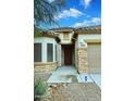 Close-up of the front entrance, showcasing the stone accents and well-manicured landscaping at 36950 W Mondragone Ln, Maricopa, AZ 85138