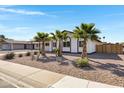 Inviting single-story home featuring desert landscaping complemented by lush, mature palm trees at 407 E Orion St, Tempe, AZ 85283