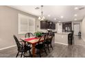Cozy dining room with modern wood floors, a wood table, and modern light fixtures at 41342 W Elm Dr, Maricopa, AZ 85138