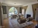 Inviting living room with a striking fireplace, large arched window, and built-in shelving at 514 W Monte Vista Rd, Phoenix, AZ 85003