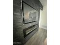 Living room featuring a modern fireplace and mounted TV with black slate surround at 5212 N 42Nd Ln, Phoenix, AZ 85019