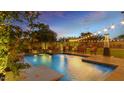 Stunning backyard pool with comfortable lounge area, a cozy firepit and outdoor patio illuminated by string lights at 5424 N 186Th Dr, Litchfield Park, AZ 85340