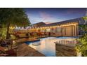 Tranquil backyard pool with seating and overhead string lights, perfect for evening relaxation and entertaining at 5424 N 186Th Dr, Litchfield Park, AZ 85340
