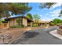 Home exterior showcasing a brick facade, desert landscaping and an expansive circular driveway at 5536 N Camelback Canyon Pl, Phoenix, AZ 85018
