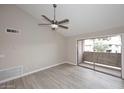 Bright living room with sliding door, wood-look floors, neutral walls, and ceiling fan at 623 W Guadalupe Rd # 279, Mesa, AZ 85210