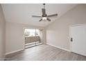 Bright living room with sliding door, wood-look floors, neutral walls, and ceiling fan at 623 W Guadalupe Rd # 279, Mesa, AZ 85210