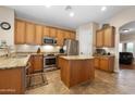 Well-lit kitchen with wooden cabinetry, stainless steel appliances, and granite countertops at 641 W Mesquite Tree Ln, San Tan Valley, AZ 85143