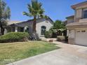 Charming single-story home with well-maintained landscaping and mature palm trees, under a clear blue sky at 6858 W Potter Dr, Glendale, AZ 85308