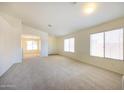 Bright living room featuring neutral carpet, white walls and plenty of natural light at 11357 W Buchanan St, Avondale, AZ 85323