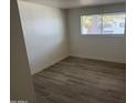 Cozy bedroom with wood-look flooring, clean white walls, and a window offering plenty of light at 1524 E Cortez St, Phoenix, AZ 85020