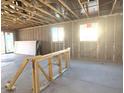 Unfinished room with exposed wooden beams and open sliding glass doors ready for customization at 15788 W Beryl Ave, Waddell, AZ 85355