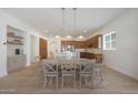 Spacious dining room has wood floors, modern light fixtures, and open kitchen concept at 20834 W Prospector Way, Buckeye, AZ 85396