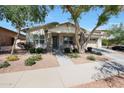 Charming home featuring mature trees, neutral stucco, stacked stone accents, and welcoming entrance at 20834 W Prospector Way, Buckeye, AZ 85396
