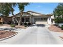 Charming home featuring mature trees, neutral stucco, stacked stone accents, and 2-car garage at 20834 W Prospector Way, Buckeye, AZ 85396