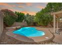 Inviting pool surrounded by lush landscaping, patio, and a rock waterfall feature at 2323 W Hunter Ct, Phoenix, AZ 85085