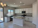 Modern kitchen featuring white cabinets, stainless steel appliances, and a central island at 2512 N Pony Ln, Casa Grande, AZ 85122